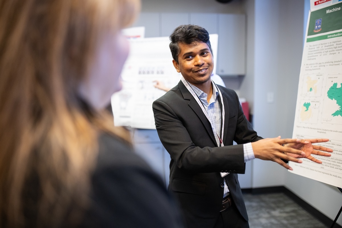 Presenter discussing poster at 2025 Research Symposium